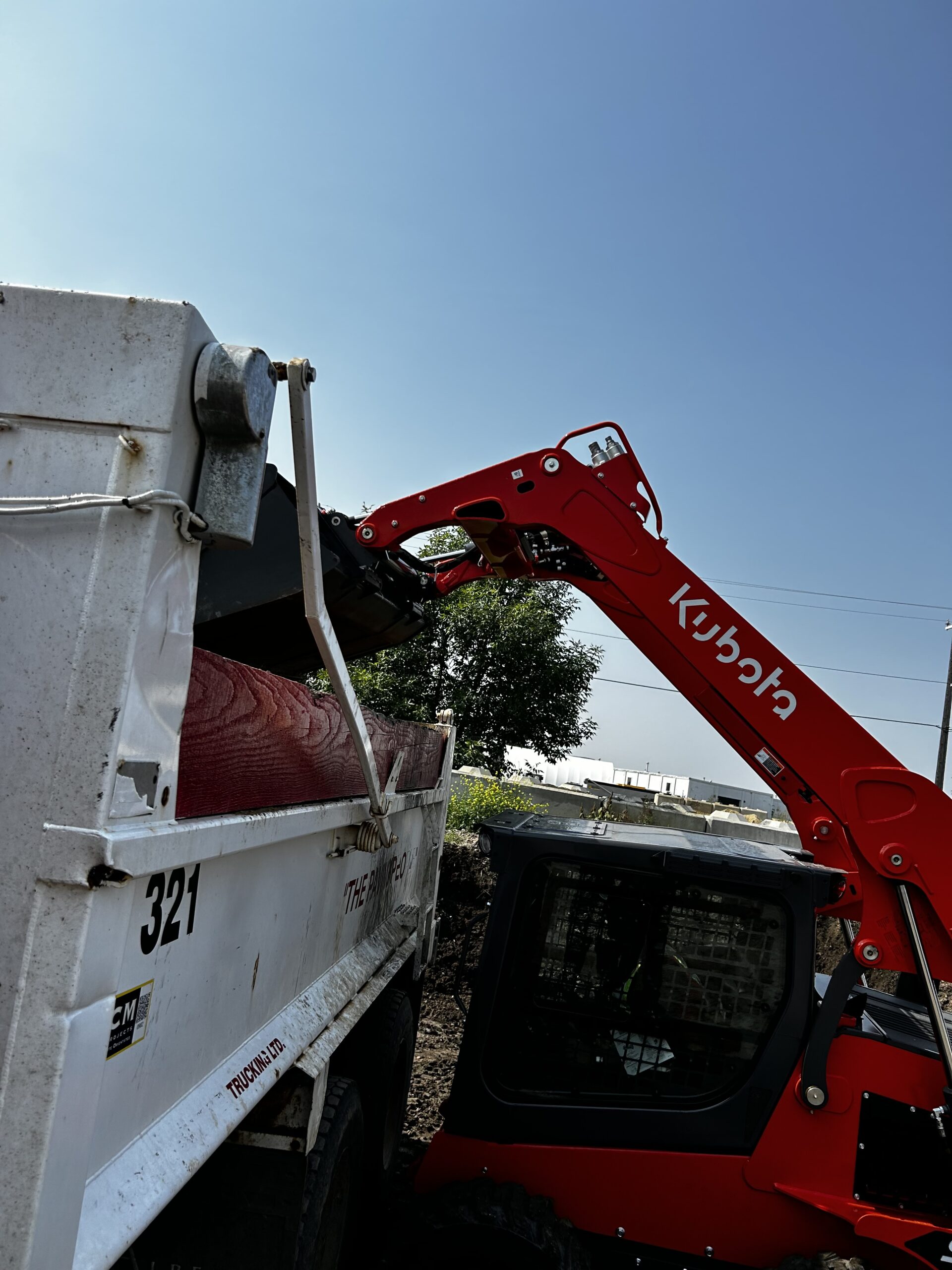 dump truck services edmonton - loading of skidsteer/Bobcat 