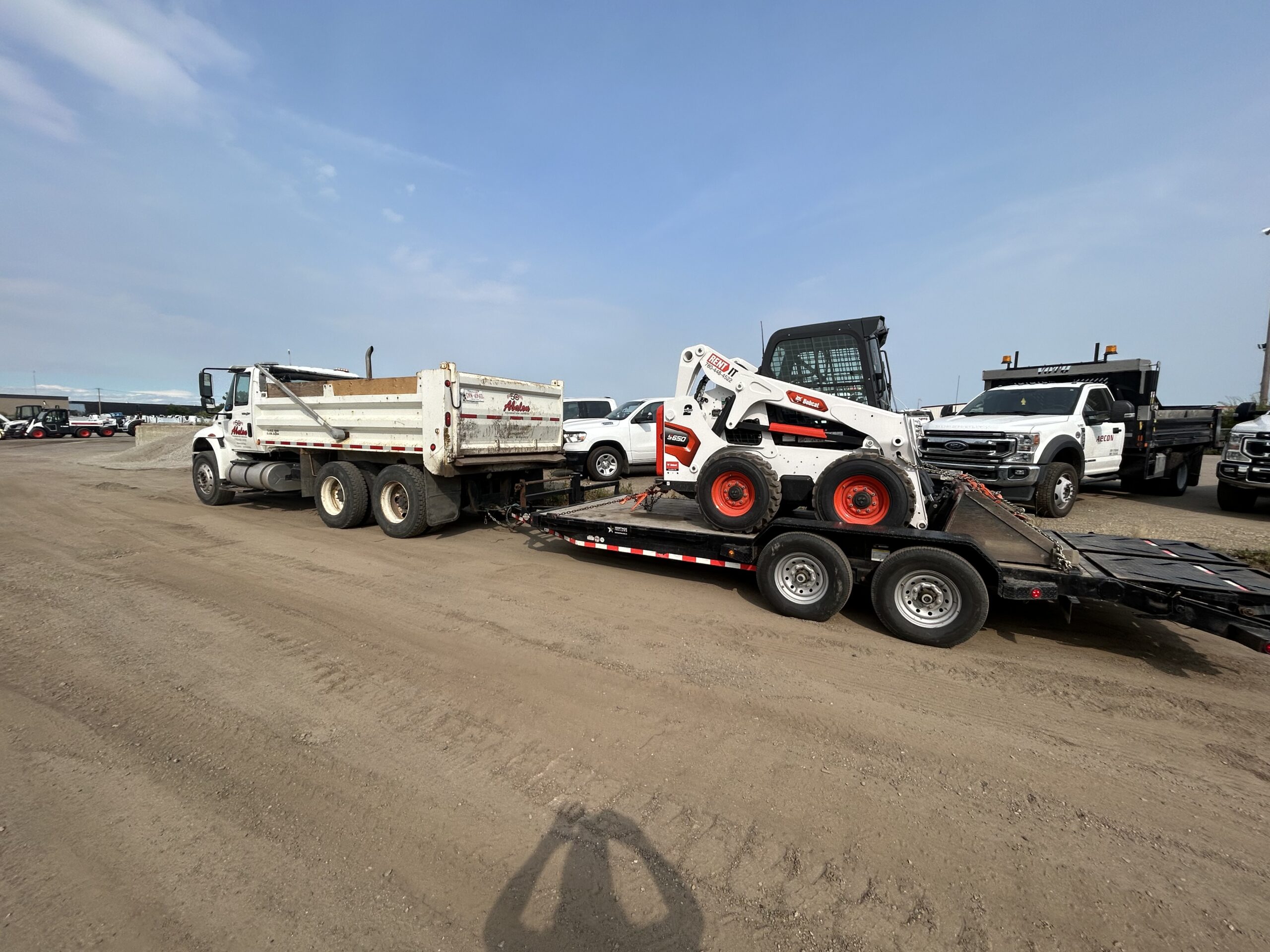 Edmonton skidsteer services - dumptruck and bobcat at jobsite
