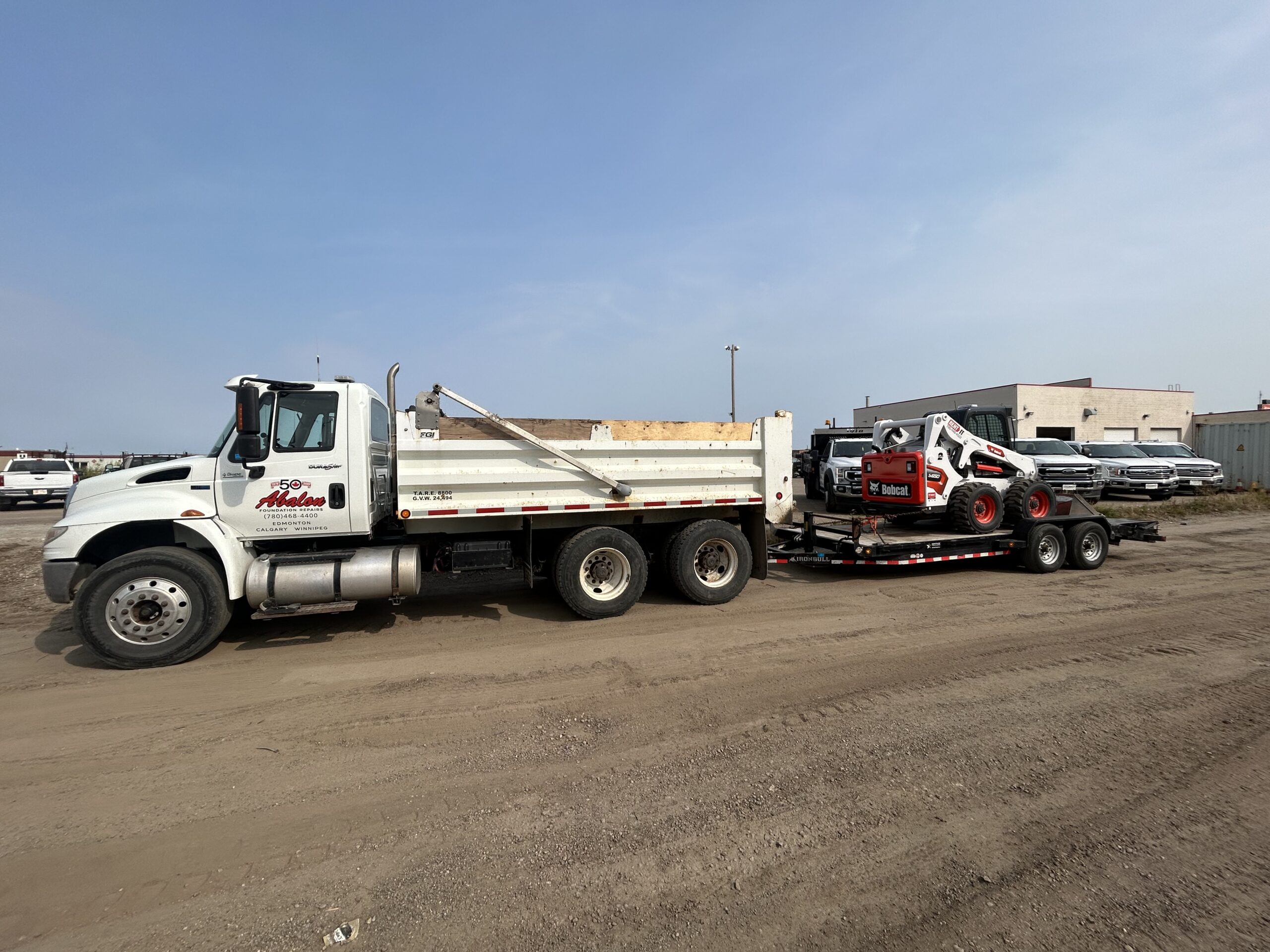 dump truck services edmonton - abalon construction - tandem dump truck with bobcat